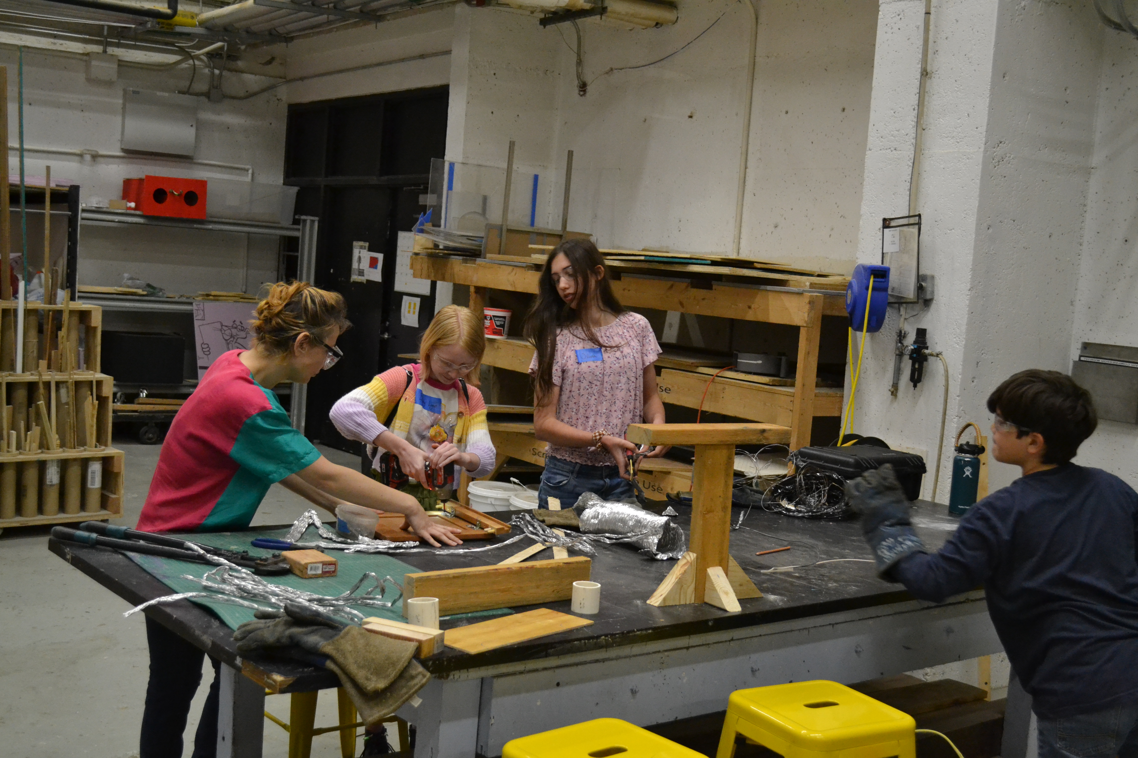 Middle schoolers transforming trash into art at the 'Art to Trash' event, guided by Dr. Choi and Mr. Duarte.