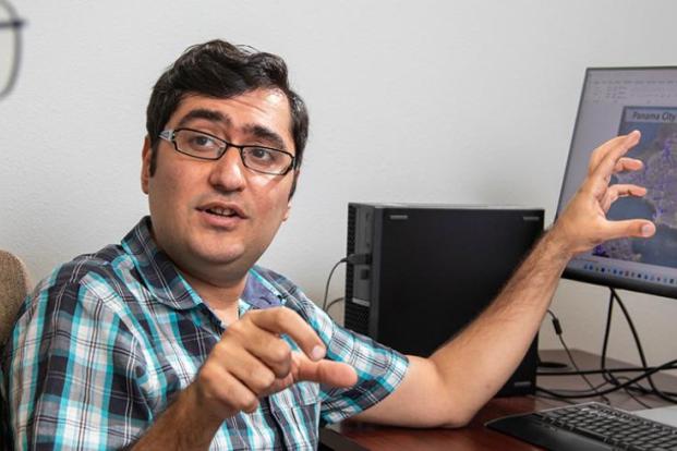 Dr. Ebrahim Ahmadisharaf discussing his research, pointing a map of Panama City, Florida