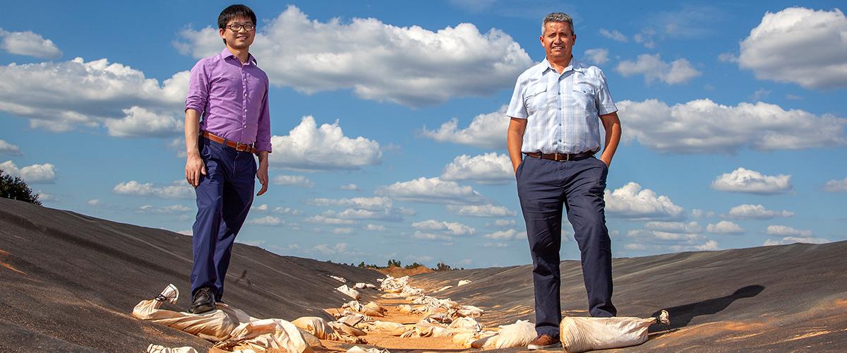 two researchers standing on a landfill cover
